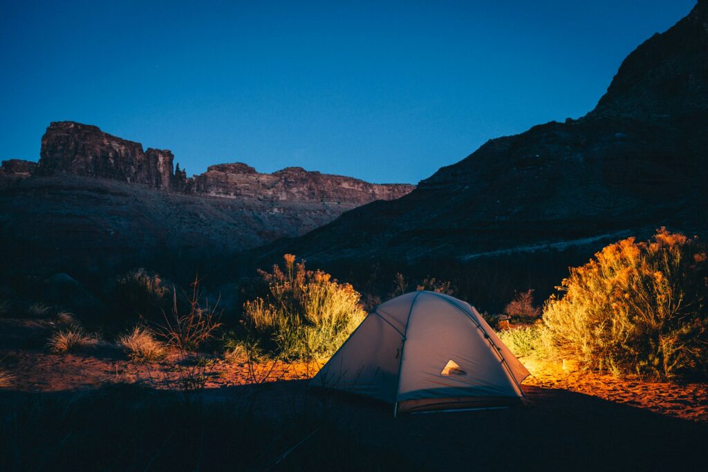 A camping tent setup near the mountains at sunset