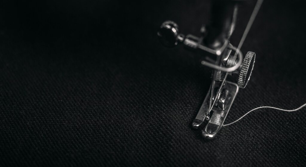 Sewing machine repairing a black fabric